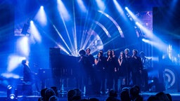 Jamie Cullum am Klavier wird auf der Bühne von zahlreichen Sängern begleitet. © fotografirma Foto: fotografirma