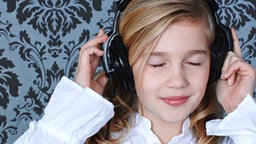 Ein junges Mädchen mit Kopfhörer hört Musik. © stock4you - Fotolia 