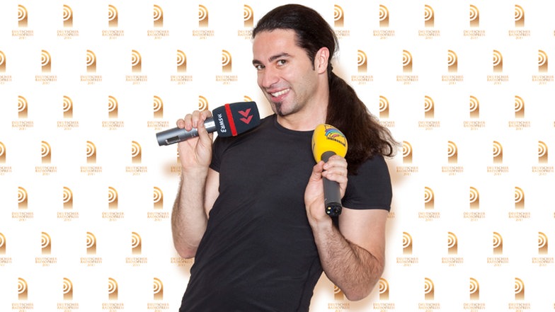 Bülent Ceylan, Comedien und Laudator bei der Gala zum Deutschen Radiopreis 2011, hält Mikrophone von SWR 3 und Radio Regenbogen in den Händen. © NDR Foto: Rainer Muranyi
