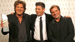 Harald Wehmeier (li.) und Andreas Altenburg (NDR 2), Sieger in der Kategorie "Beste Comedy", mit Laudator Tim Mälzer (Mitte). © AR/NDR Foto: AR