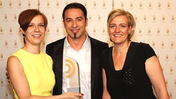 Jenni Zylka und Leslie Rosin (WDR 3 Homestory), Sieger in der Kategorie "Beste Sendung", mit Laudator Bülent Ceylan. © AR/NDR Foto: AR