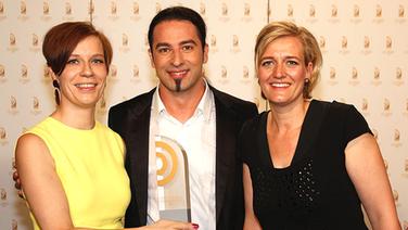 Jenni Zylka und Leslie Rosin (WDR 3 Homestory), Sieger in der Kategorie "Beste Sendung", mit Laudator Bülent Ceylan. © AR/NDR Foto: AR