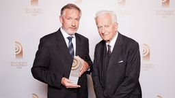 Martin Durm (SWR2), Preisträger in der Kategorie "Beste Reportage", posiert mit Laudator Richard von Weizsäcker vor einer Fotowand im Schuppen 52 in Hamburg. © NDR 