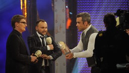 Laudator Robbie Williams überreicht den Preis an Christian Bollert und Marcus Engert (detektor.fm). © Sebastian Gerhard 