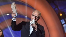 Volker Wieprecht hält während seiner Dankesrede seinen Radiopreis in die Höhe © NDR Foto: fotografirma