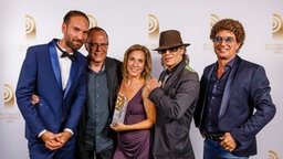 Ron Perduss und Nina Siegers von radioBerlin 88,8 freuen sich mit Laudator Atze Schröder und Udo Lindenberg über ihren Radiopreis für die "Beste Programmaktion". Foto: Morris Mac Matzen