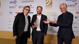 Gewinner in der Kategorie "Beste Reportage": Jens Schnellhass und Tobias Nagorny von Bremen Zwei mit Laudator Marcel Reif. © Deutscher Radiopreis / Morris Mac Matzen Foto: Morris Mac Matzen