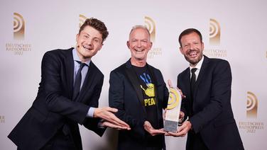 Gewinner in der Kategorie "Beste Programmaktion": Mike Thiel und Johannes Ott von Radio Gong 96.3 mit Laudator Felix von der Laden (links) © Deutscher Radiopreis / Morris Mac Matzen Foto: Morris Mac Matzen