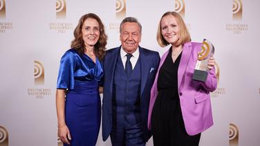 Gewinnerinnen in der Kategorie "Beste Reportage": Caroline Uhl und Linda Grotholt von SR3 Saarlandwelle mit Laudator Roland Kaiser. © Deutscher Radiopreis / Morris Mac Matzen Foto: Morris Mac Matzen